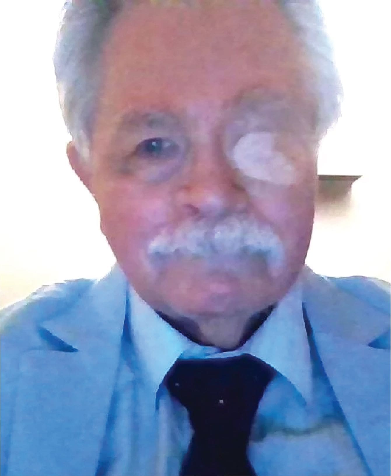 Older gentleman in blue suit with mustache